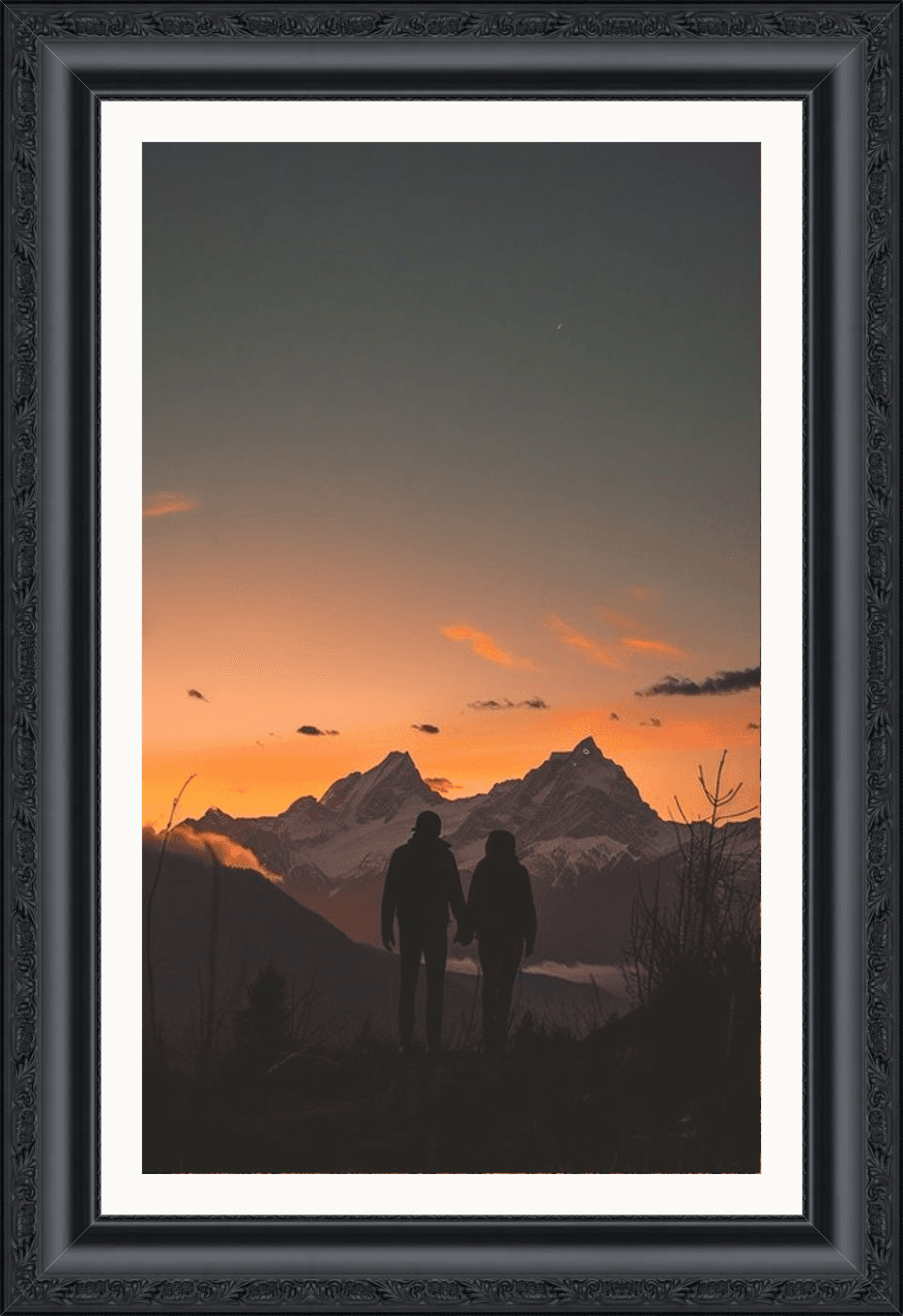 Moldura preta entalhada com foto de um casal de mãos dadas observando o pôr do sol nas montanhas, exemplo do resultado do simulador